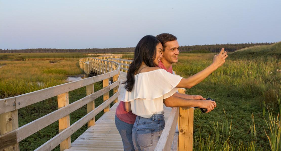 people taking a selfie on a boardwalk